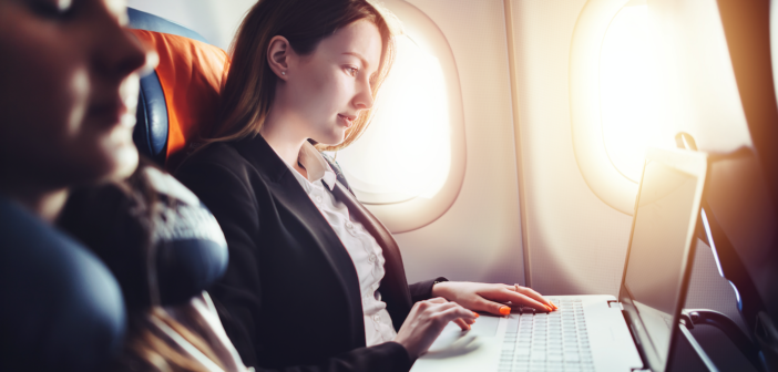 a female working on a laptop in an airplane