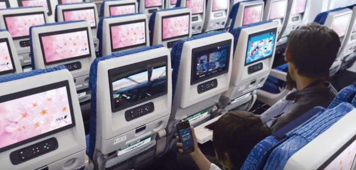 a passenger watching a seatback entertainment screen in an ana boeing 777 cabin