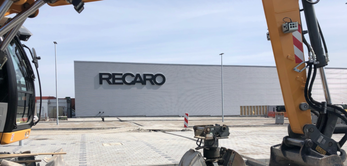 A digger in front of recaro's hq, being used to build an extension