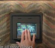 a passenger on emirates airline in 1992 using the small square seatback entertainment screen