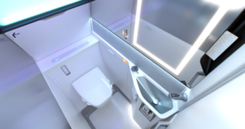 photo of the collins lavatory for the boeing 737. Top view showing an illuminated mirror and grab handles
