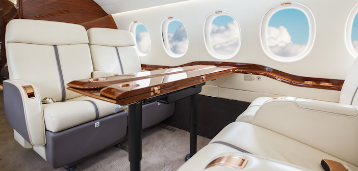 the cabin interiors of a business jet, with leather seating and a wood dining table