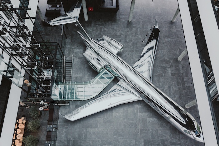 Looking down on AeroTime Hub’s office building in Vilnius Lithuania, which has a full-size chrome business jet in the atrium