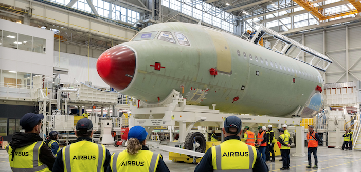 Guests standing in front of a plane at the Airbus A320 FAL inauguration ceremony