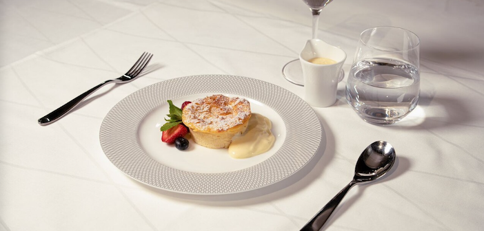 Summer berry bread and butter pudding served in a fancy plate in BA first class