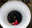 A Virgin Atlantic crew member sitting in an engine cowling
