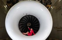 A Virgin Atlantic crew member sitting in an engine cowling