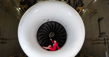 A Virgin Atlantic crew member sitting in an engine cowling
