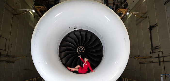 A Virgin Atlantic crew member sitting in an engine cowling