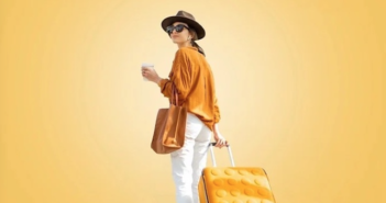 a lady in a yellow and white outfit, with a matching suitcase