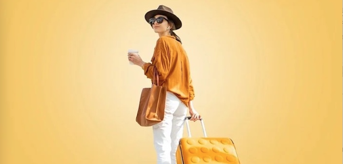 a lady in a yellow and white outfit, with a matching suitcase
